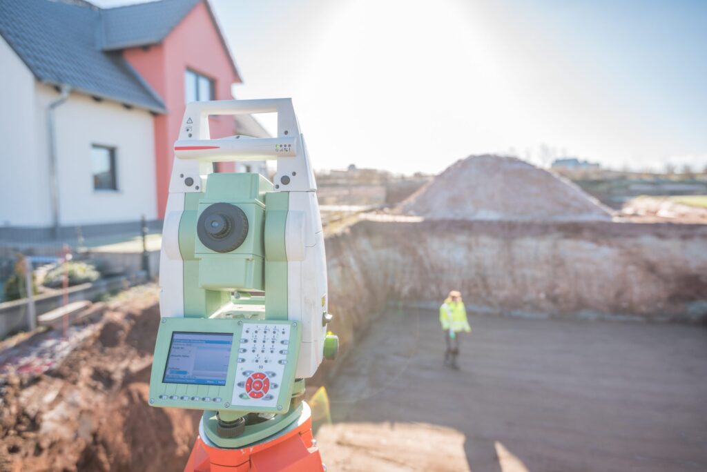 Total Station being used on construction site, conducting an as-built survey